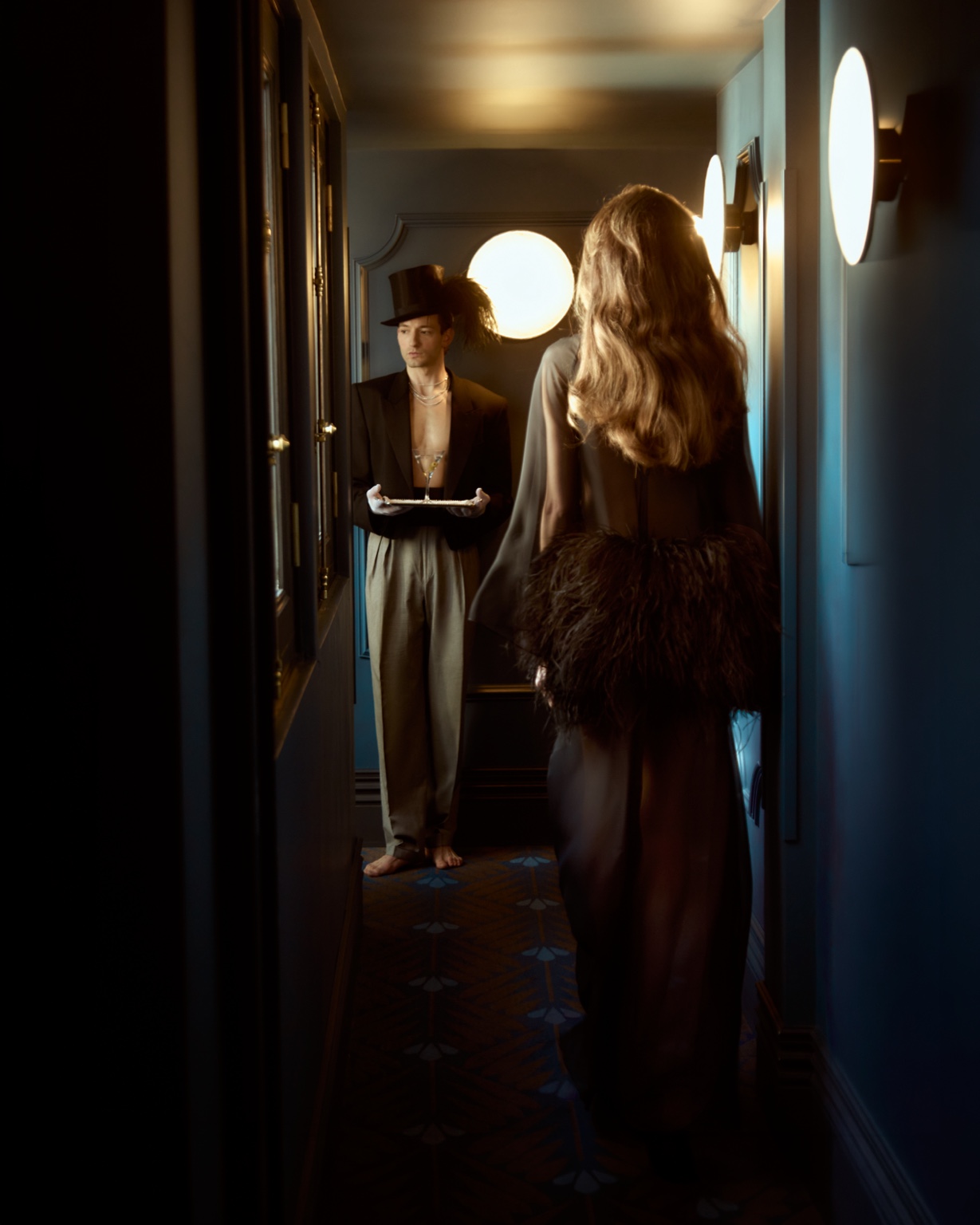 The butler waits in a dark corridor