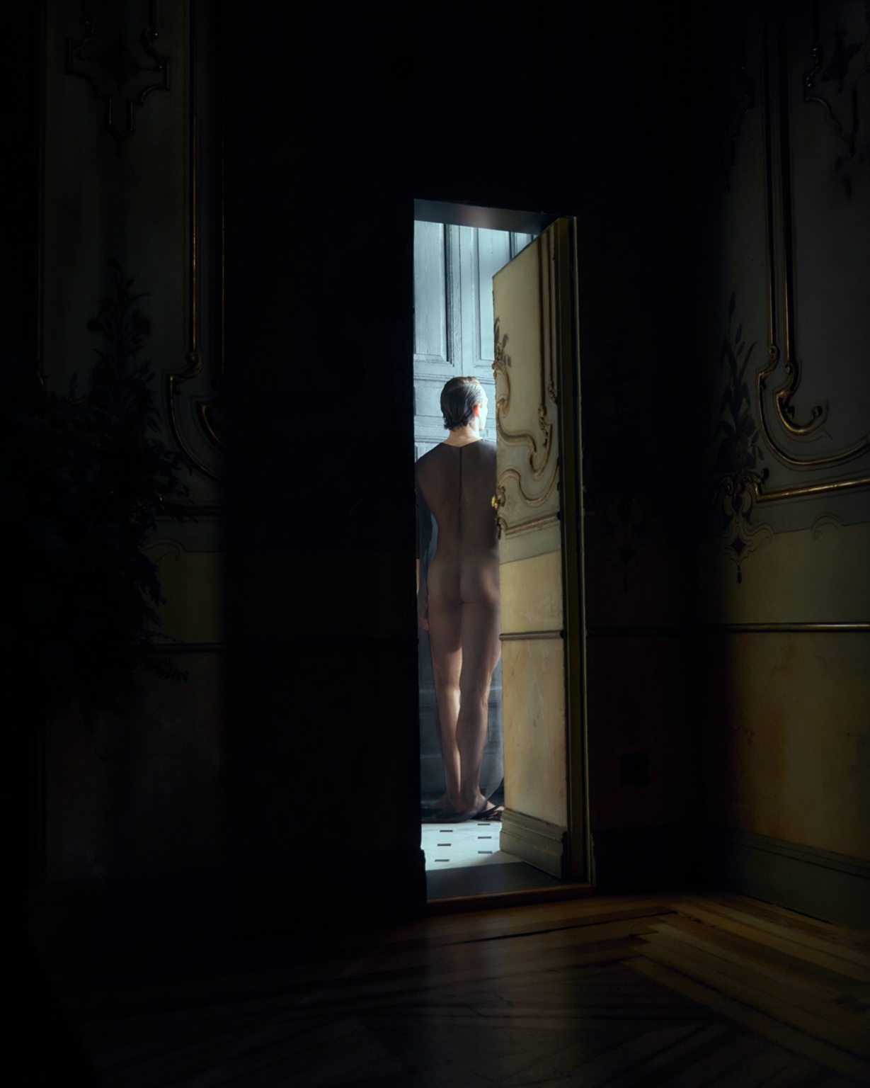 A woman standing in an illuminated doorway
